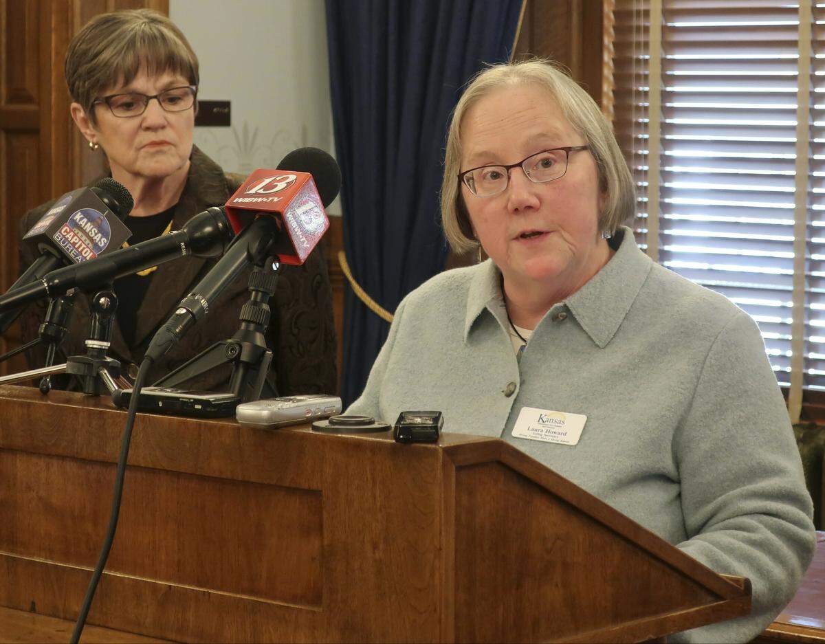 Laura Howard, right, secretary of the Kansas Department for Children and Families, answers questions from reporters a news conference as Gov. Laura Kelly watches to the left, Thursday, Feb. 14, 2019, at the Statehouse in Topeka, Kansas.