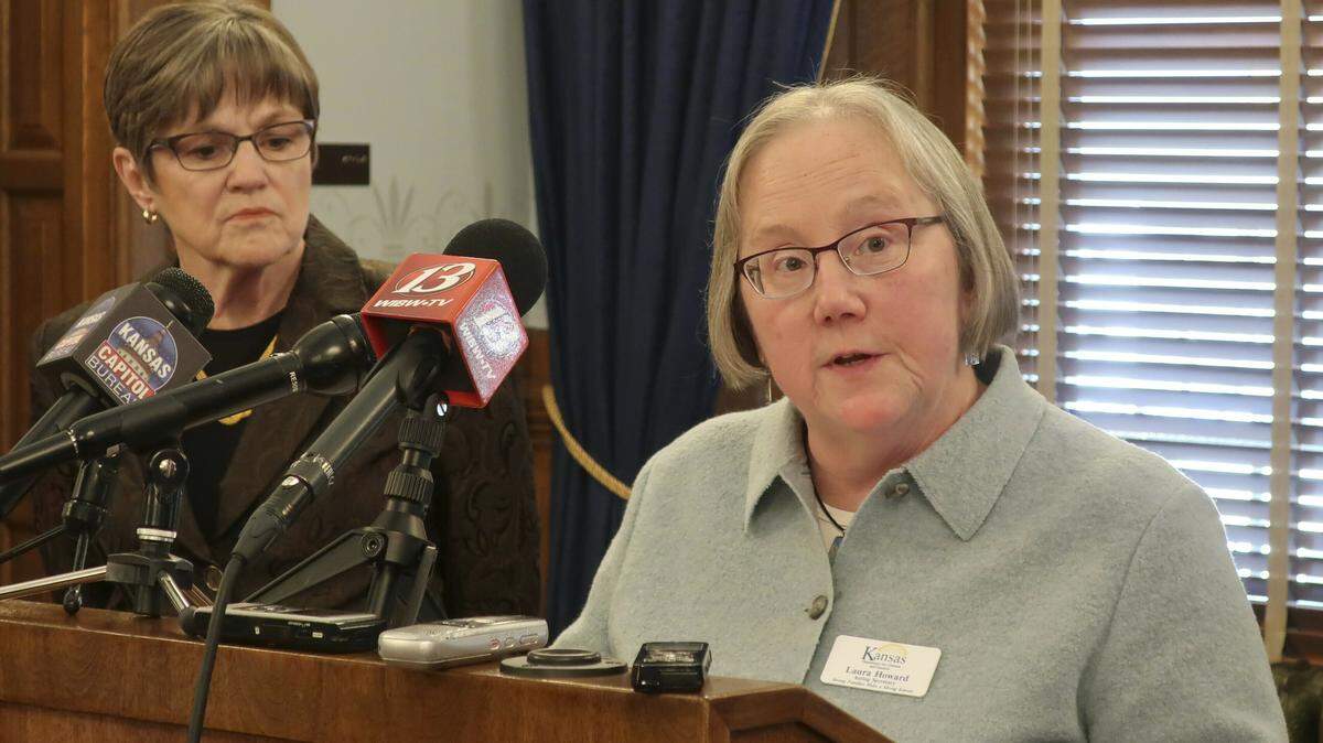 Laura Howard, right, secretary of the Kansas Department for Children and Families, answered questions from reporters at a 2019 news conference as Gov. Laura Kelly watched to the left at the Statehouse in Topeka.