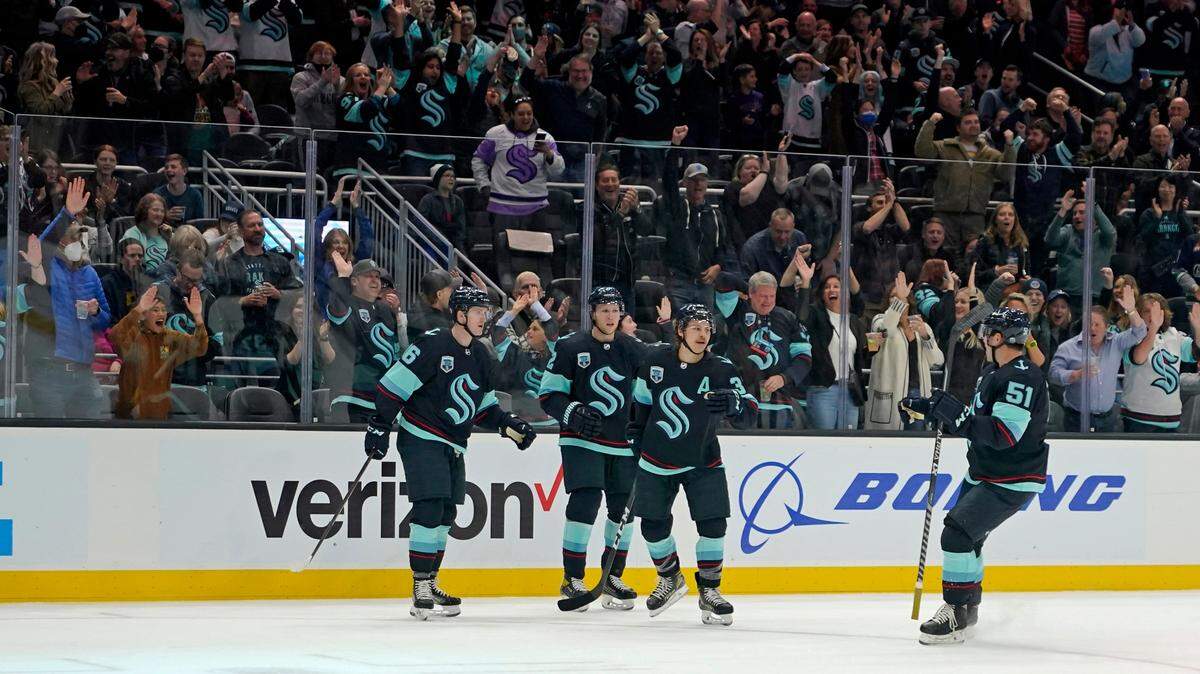 Fans cheer after Seattle Kraken left wing Jared McCann, left, scored a goal against the San Jose Sharks during the first period of an NHL hockey game, Friday, April 29, 2022, in Seattle. (AP Photo/Ted S. Warren)