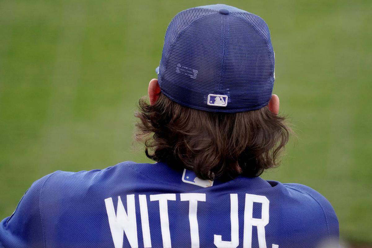 Kansas City Royals third baseman Bobby Witt Jr. watches from the dugout during a spring training game against the Seattle Mariners in Peoria, Ariz.