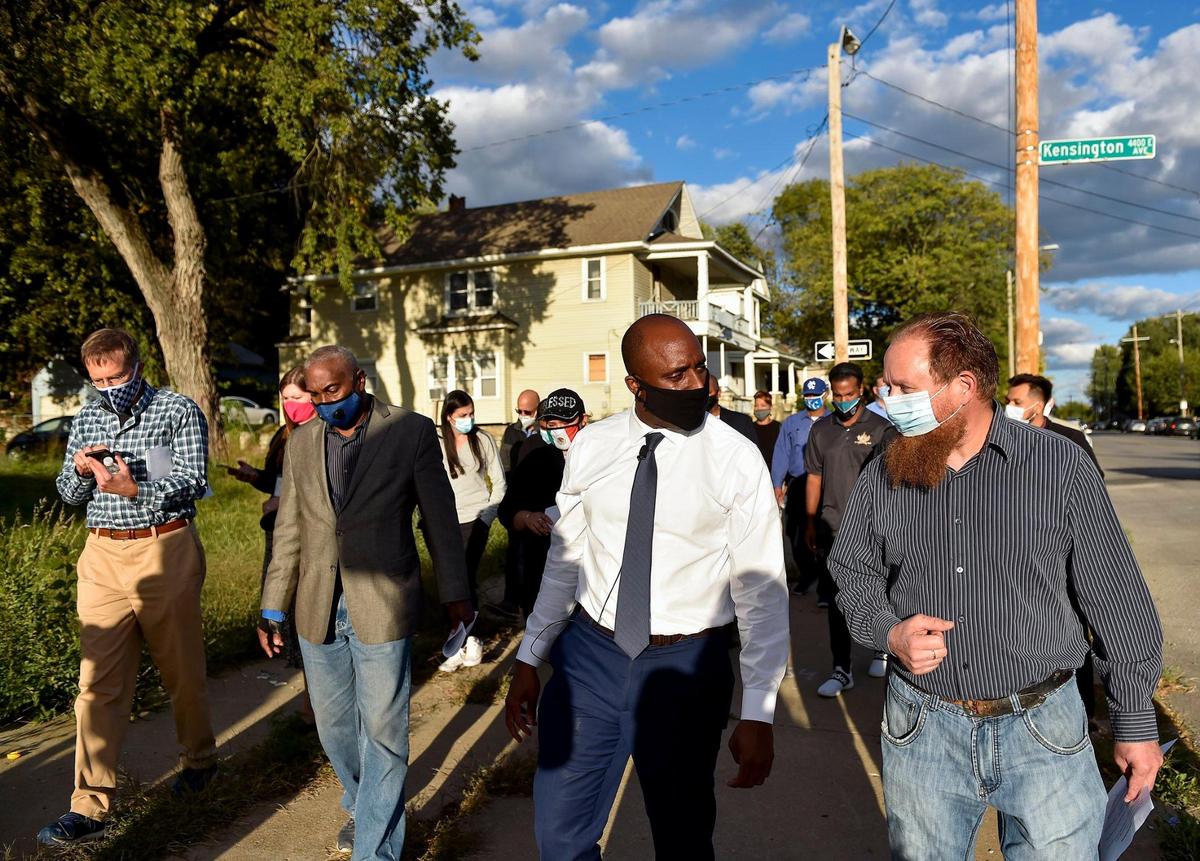 Walking along E. 9th Street, Kansas City Mayor Quinton Lucas, second right, talks with Lykins Neighborhood Association president Robert Ontman, right, while on a tour of Lykins Neighborhood Thursday, Oct. 1, 2020. Lucas sought community input relating to Reform Project KC, a four-pronged crime prevention strategy.