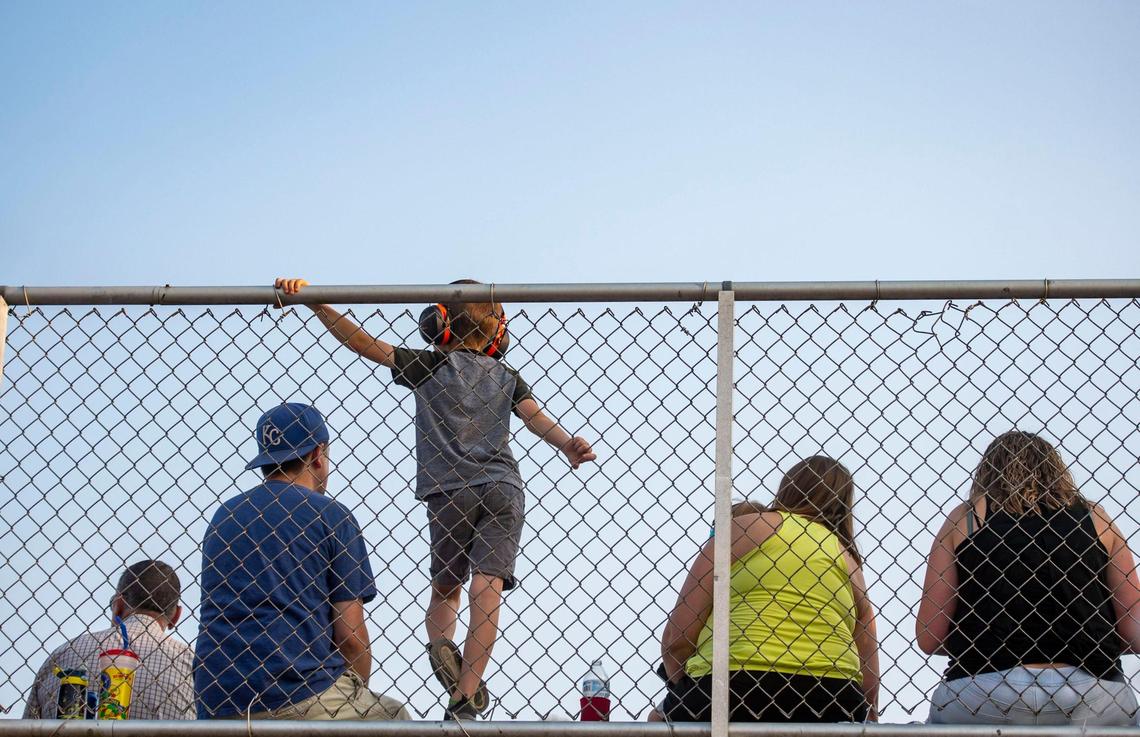 People sit in the the stands before the demolition derby begins at the Platte County Fair, Thursday, July 22, 2021, in Tracy, Missouri.