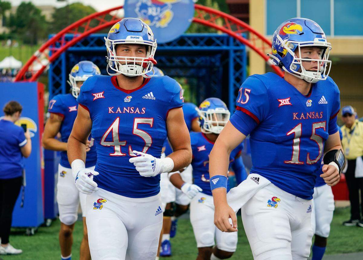 Kansas Jayhawks tight end Trevor Kardell (45) and quarterback Miles Fallin (15) take the field before the game against the South Dakota Coyotes at David Booth Kansas Memorial Stadium on Sept. 3, 2021.