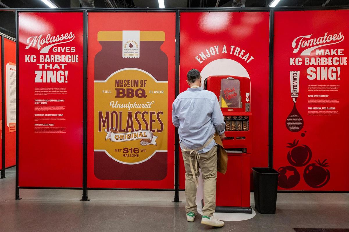 Corey McGhee finishes up at a candy vending machine from the 1950s at the Museum of BBQ.