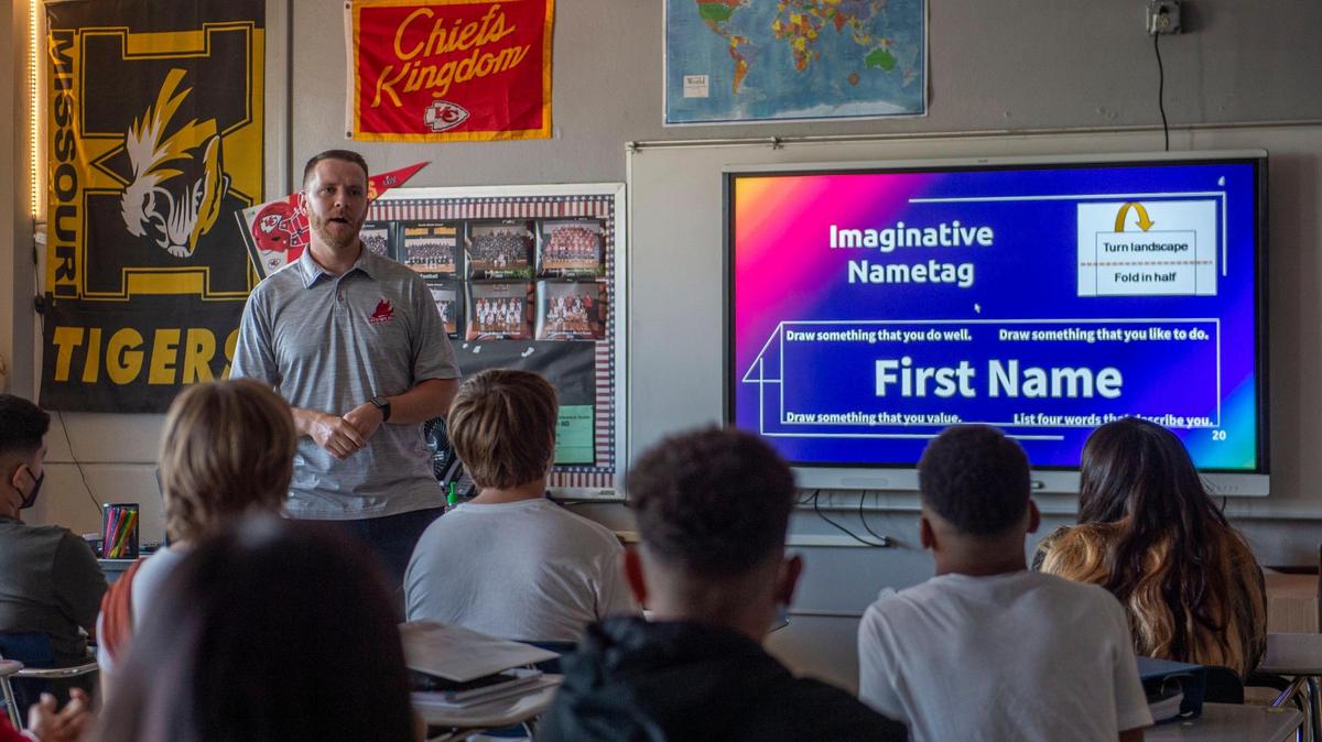 Eighth-grade teacher Caleb Pitts greets his students on the first day of school at Nowlin Middle School in Independence. The district has voted to switch to a four-day week.