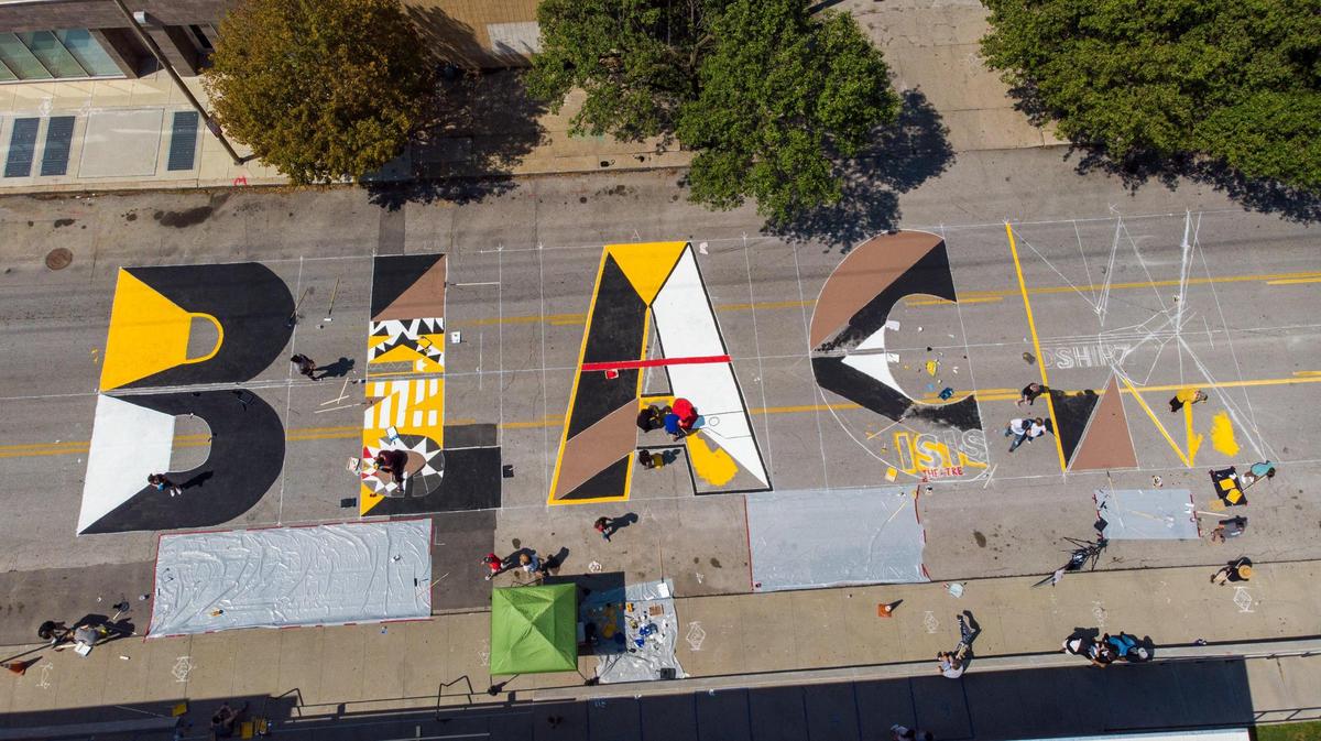 Artists and volunteers work on a giant Black Lives Matter mural at 31st St. and Troost Ave. Saturday, Sep. 5, 2020. Six unique Black Lives Matter murals were painted at the same time across Kansas City..