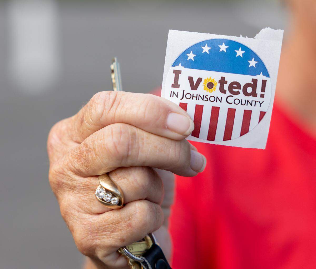 Deanna Lowrey holds up a voting sticker after voting in the primary election at her Johnson County polling place on Tuesday, August 6, 2024.