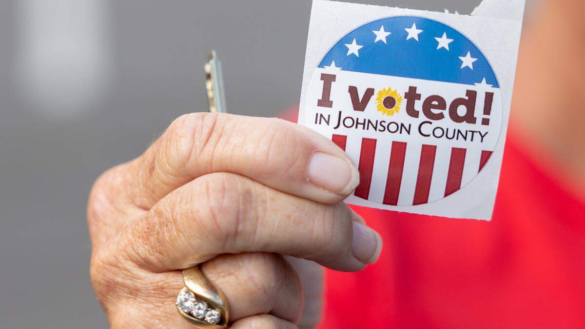 A Johnson County voter holds up a voting sticker.