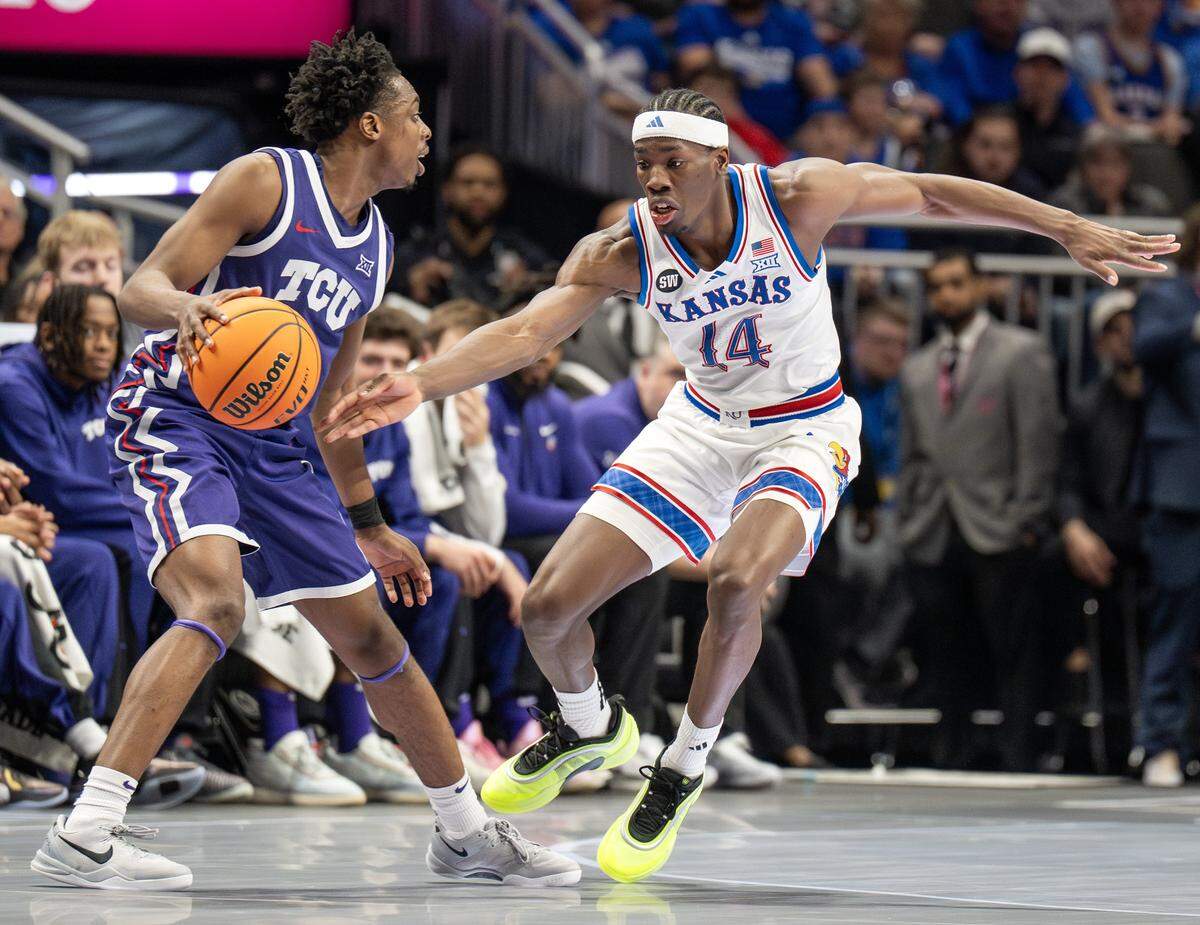 Texas Christian University Horned Frogs guard Jayden Pierre (1) shields the ball from Kansas Jayhawks guard Melvin Council Jr. (14) during the second half of a Big 12 Men's Basketball Tournament game at T-Mobile Center on Thursday, March 12, 2026, in Kansas City.
