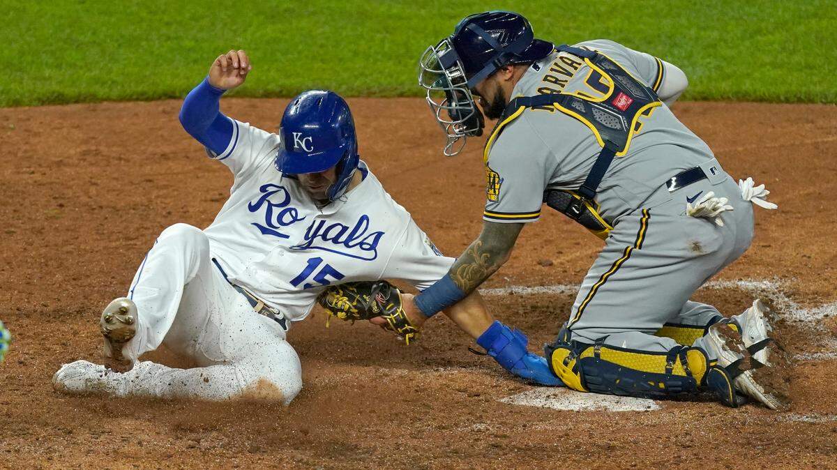 Kansas City Royals’ Whit Merrifield gets past Milwaukee Brewers catcher Manny Pina to score on a single by Andrew Benintendi during the eighth inning of a baseball game Tuesday, May 18, 2021, in Kansas City, Mo. (AP Photo/Charlie Riedel)