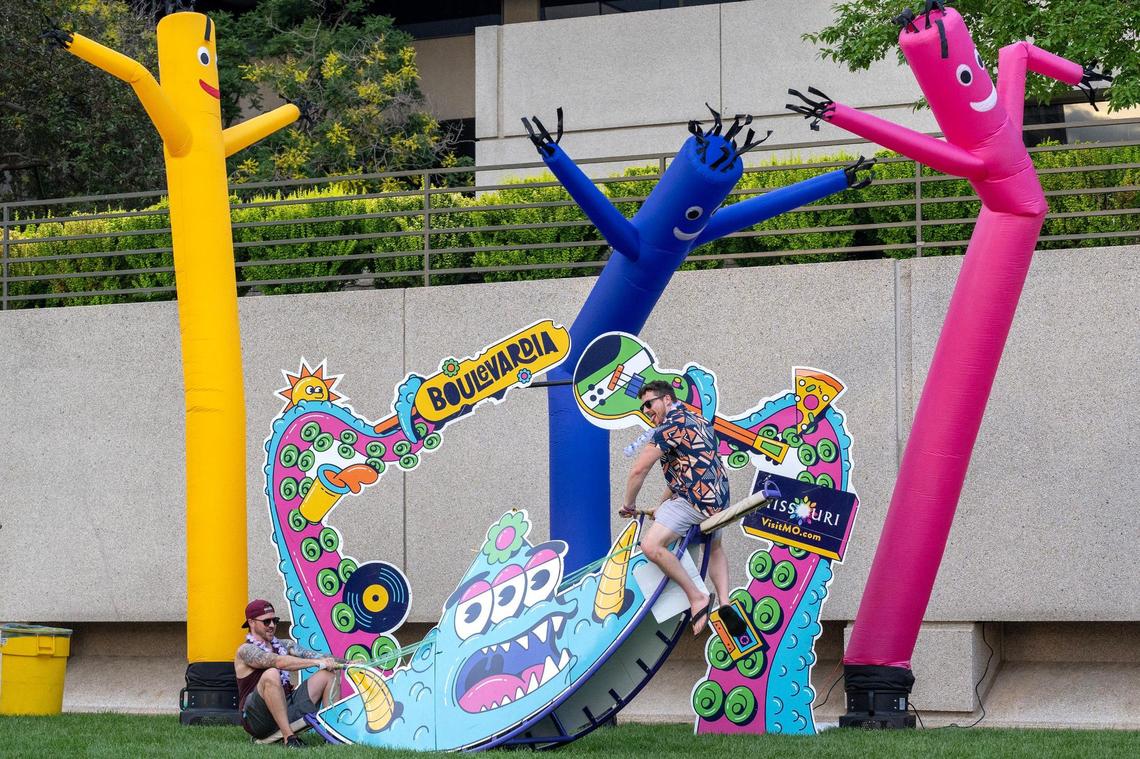 Visitors ride a teeter-totter decorated with Boulevardia-themed designs during the festival on Saturday, June 14, in Kansas City.