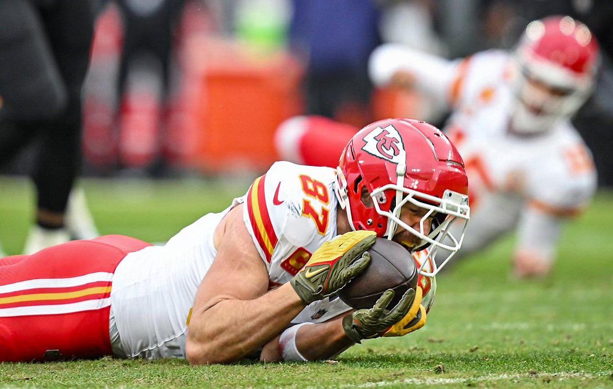 Kansas City Chiefs quarterback Patrick Mahomes (15) watches from the ground behind while tight end Travis Kelce (87) stretches out and grabs a pass from a scrambling Mahomes in the second quarter against the Baltimore Ravens Sunday, Jan. 28, 2024, during the AFC Championship Game in Baltimore.