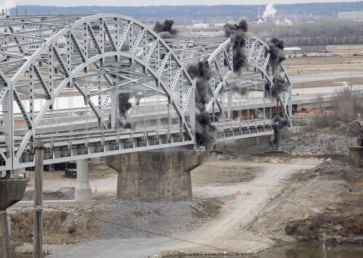 A series of photos capture the sequence as the northern section of the Buck O’Neil Bridge crashes to the ground as explosive charges go off starting the demolition.