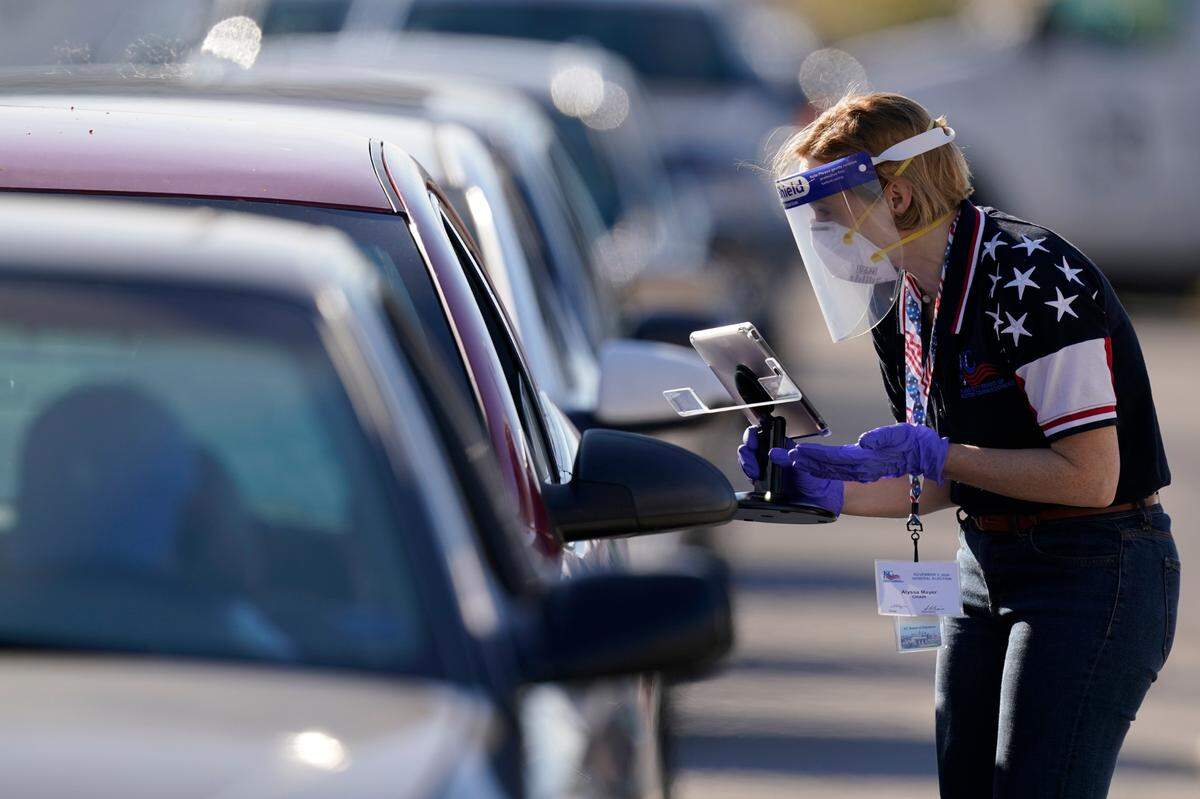 An election worker instructs a voter at a drive-thru polling location at Kansas City’s Union Station on Tuesday. The location was established to provide access for people who have tested positive for COVID-19 and for disabled voters. 
