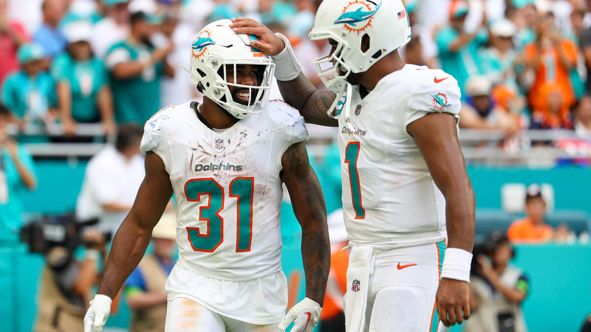 Miami Dolphins quarterback Tua Tagovailoa (1) congratulated running back Raheem Mostert (31) after scoring a touchdown against the Denver Broncos in the third quarter at Hard Rock Stadium.
