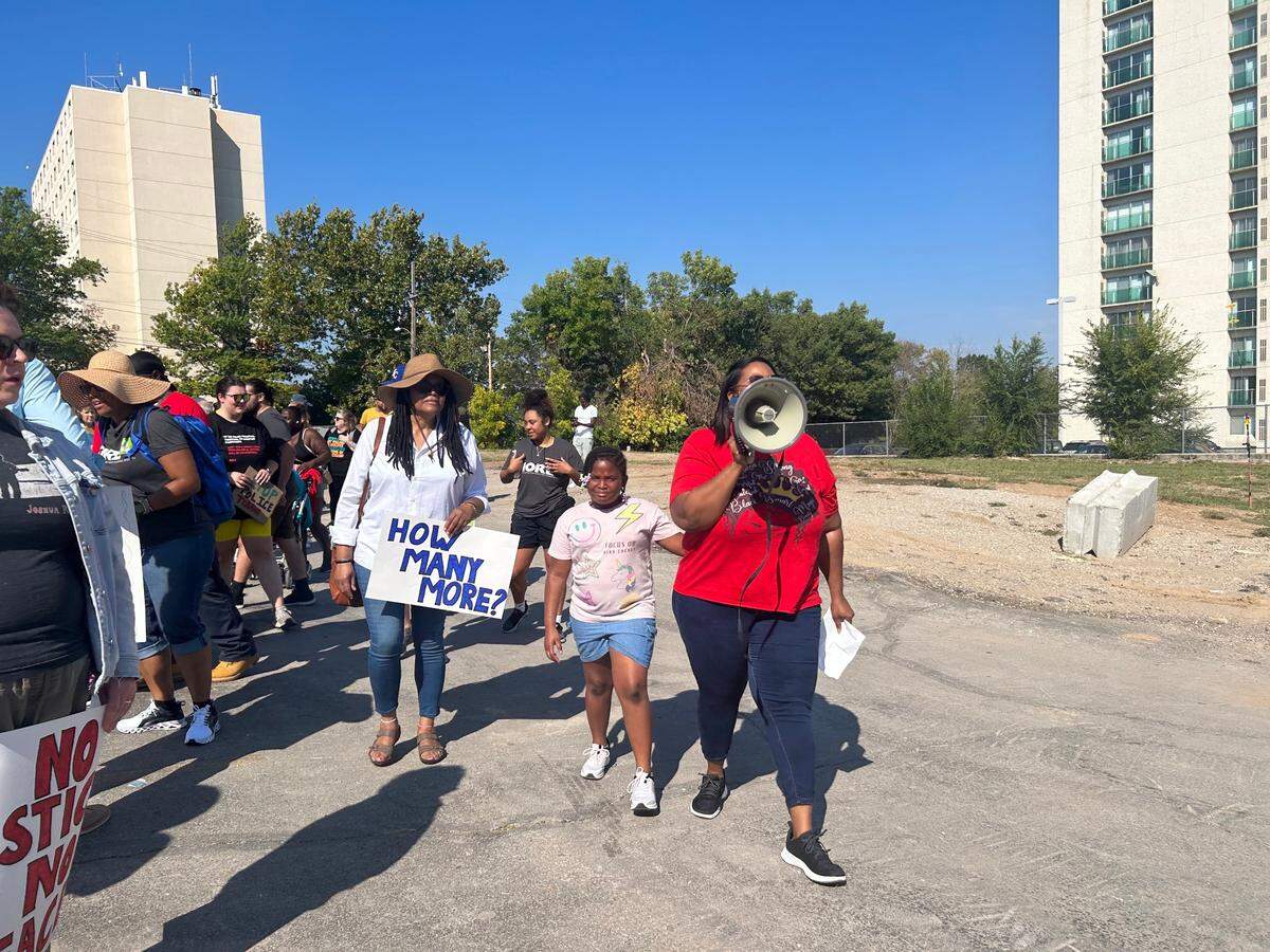 Demonstrators marched from through Kansas City Saturday, holding signs asking for a DOJ investigation.
