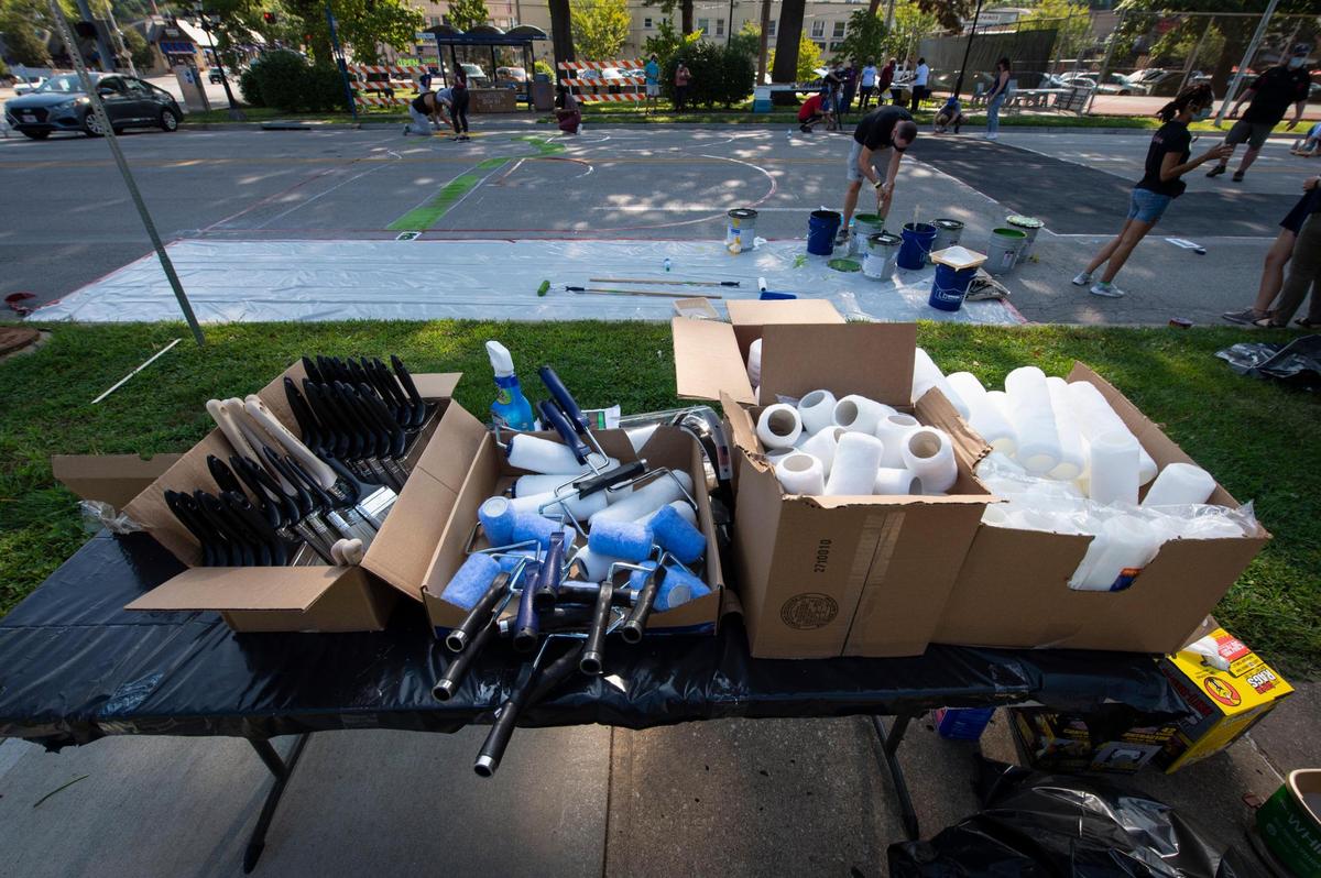 Paint brushes and rollers were at the ready for volunteers to use to help paint the Black Lives Matter Mural Saturday on Brookside Blvd. near 63rd St.