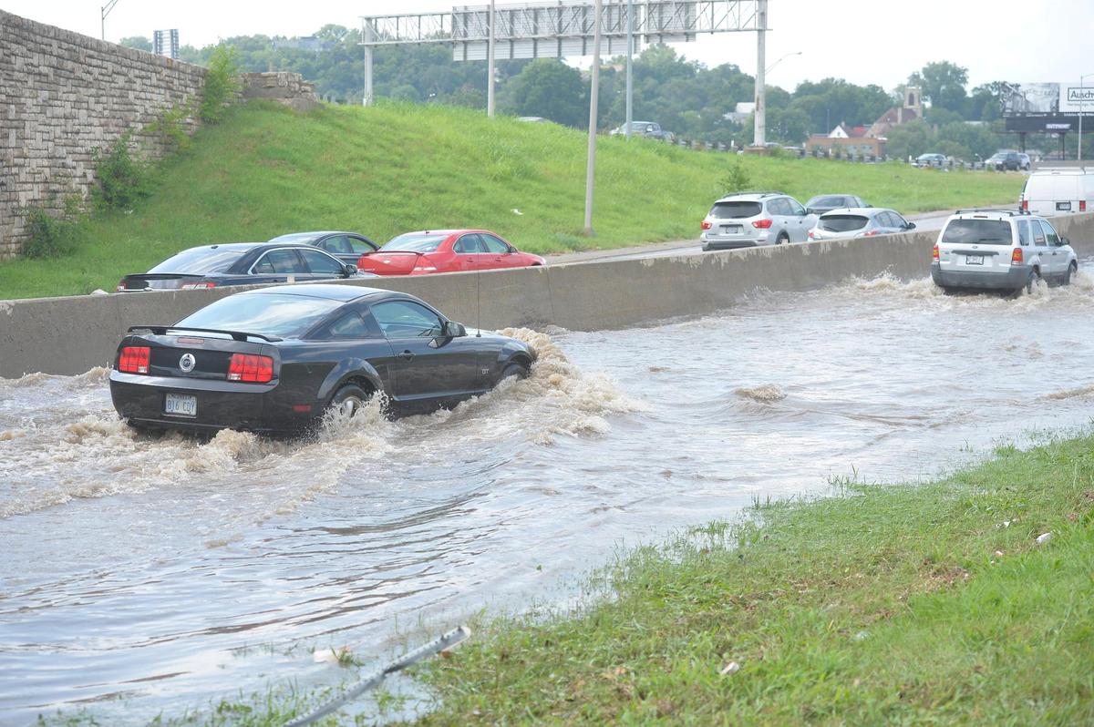 Cars splash through floodwater on the Southwest Trafficway on ramp to northbound Interstate 35 heading toward downtown Kansas City, Wednesday after heavy rains flooded the area. The interstate was impassible for a while due to water pooling in the lanes.