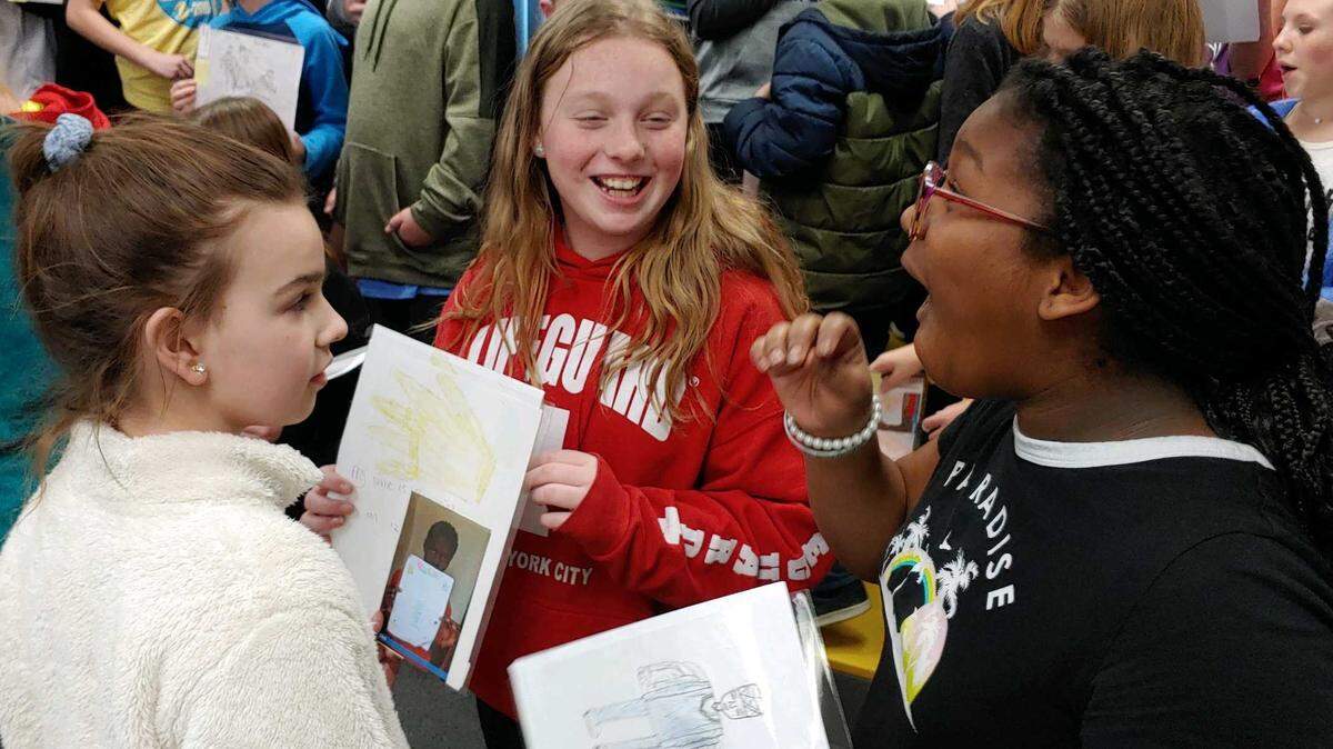 Hawthorn Hill Elementary School students Ava Rosenboum, left, Oona Mcgee, and Jaedyn McNeil share the artwork they received in a special exchange with student artists in Nigeria.