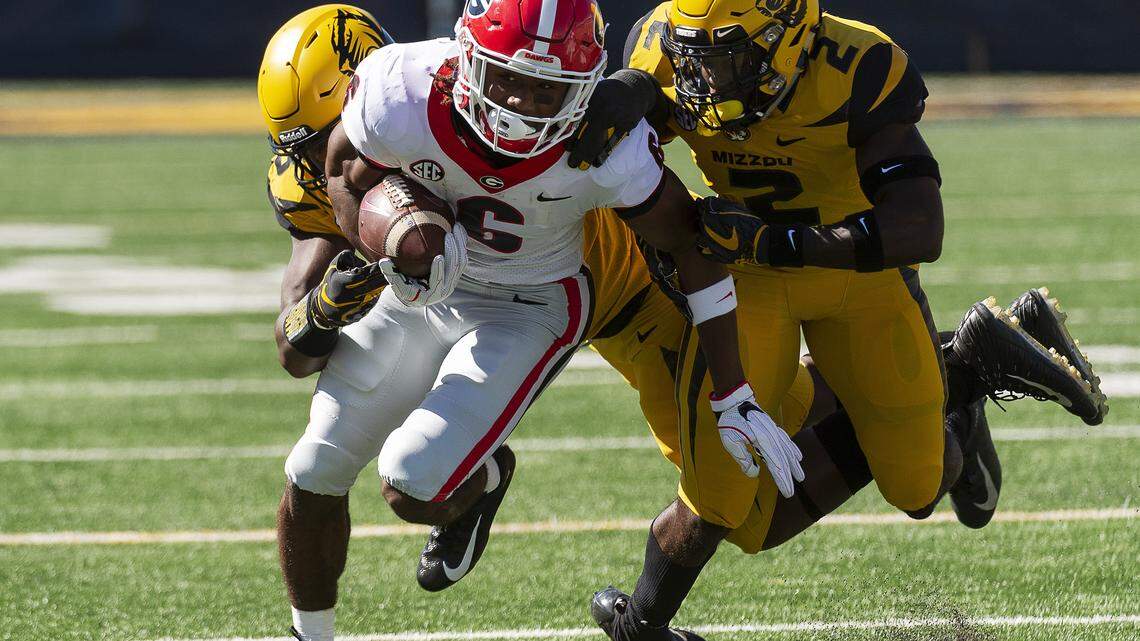 Georgia running back James Cook, center, is tackled by Missouri’s DeMarkus Acy, right, and Tre Williams, left, during the first half of an NCAA college football game Saturday, Sept. 22, 2018, in Columbia, Mo. (AP Photo/L.G. Patterson)