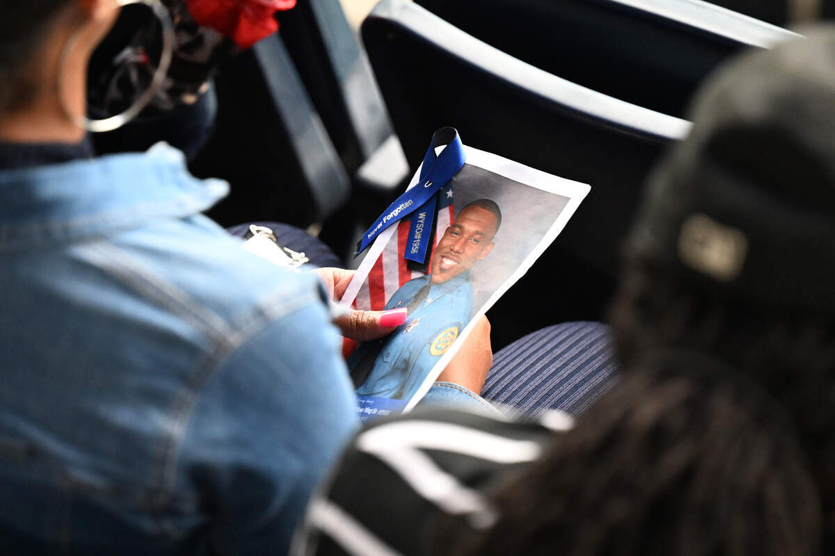 A funeral goer holds onto a program for the funeral of Wyandotte County Sheriff's deputy Elijah Ming on Monday, August 11, 2025, at Children's Mercy Park.