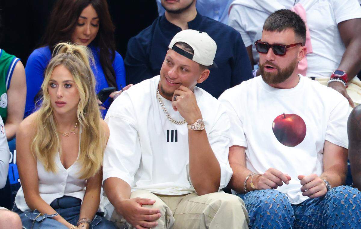Kansas City Chiefs quarterback Patrick Mahomes, center, sits with wife Brittany and tight end Travis Kelce during an NBA playoff game between the Dallas Mavericks and Minnesota Timberwolves.