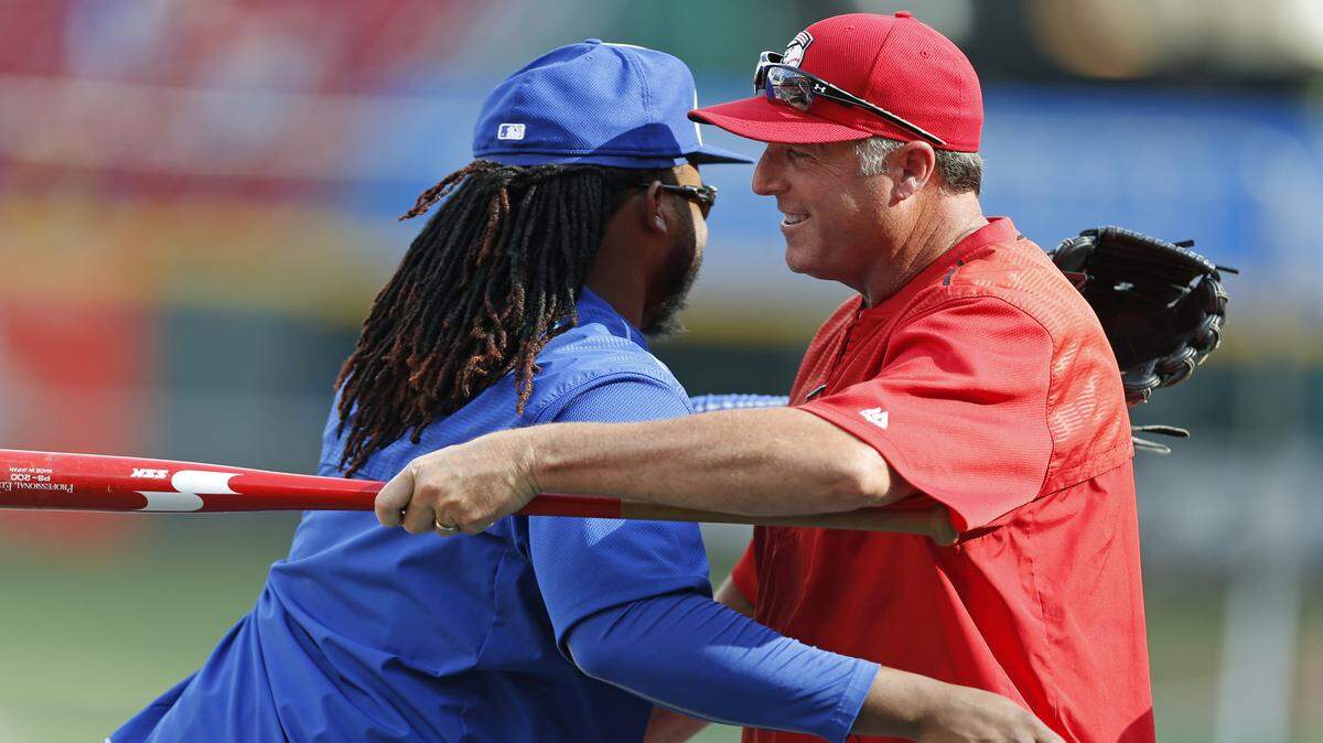 Kansas City Royals pitcher Johnny Cueto, left, hugs Cincinnati Reds manager Bryan Price before a baseball game, Tuesday, August 18, 2015, in Cincinnati. Cueto was traded to the Royals from the Reds in July. 