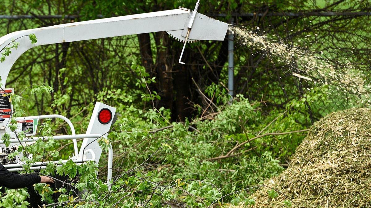 In this file photo, a contractor uses a wood chipper to help get rid of branches in a Kansas City garden. 