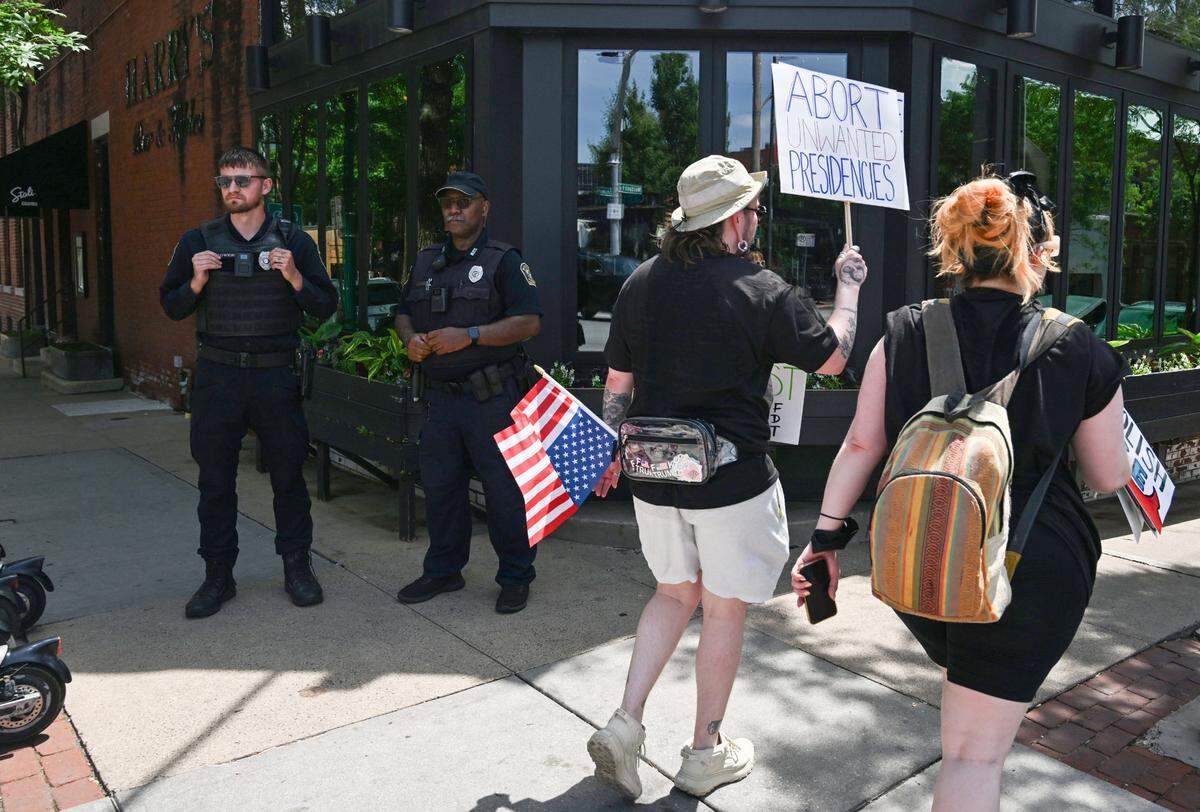KCPD police officers stand by as demonstrators march toward Westport after rallying at the “No Kings” day of defiance Saturday, June 14, 2025, at Mill Creek Park in Kansas City.