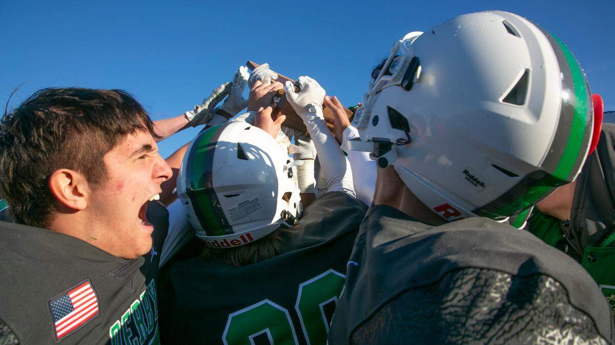 Members of the Derby Panthers grabbed the state championship trophy Saturday after breating the Blue Valey North Mustangs at the College Boulevard Activity Center in Olathe.