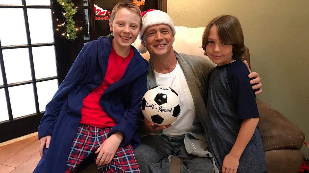 Hudson Harris (right) poses with Andrew Koch and Amye Gousset, who play his brother and mother, on the set of “The Favorite.”