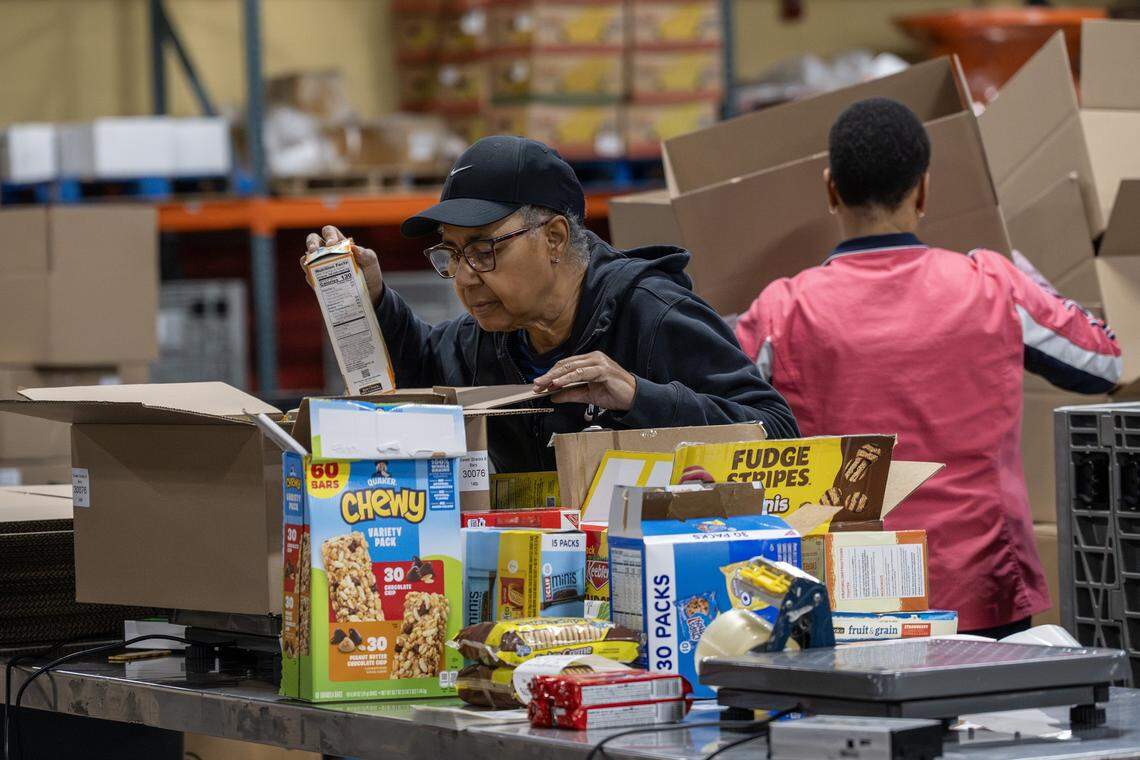 A Harvesters volunteer packs boxed goods at the distribution warehouse on Tuesday, Oct. 28, 2025, in Kansas City. The food bank is working to supply local pantries amid the government shutdown affecting SNAP benefits.