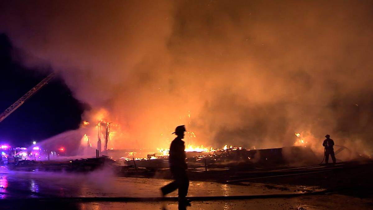 A firefighter crosses in front of houses under construction that were destroyed by fire early Monday in southern Overland Park. The fire spread quickly and threatened a nearby occupied home, fire officials said.