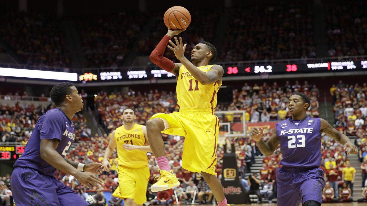 Iowa State guard Monte Morris (11) drives to the basket between Kansas State defenders Marcus Foster, left, and Nigel Johnson (23) during the first half of an NCAA college basketball game, Tuesday, Jan. 20, 2015, in Ames, Iowa. 
