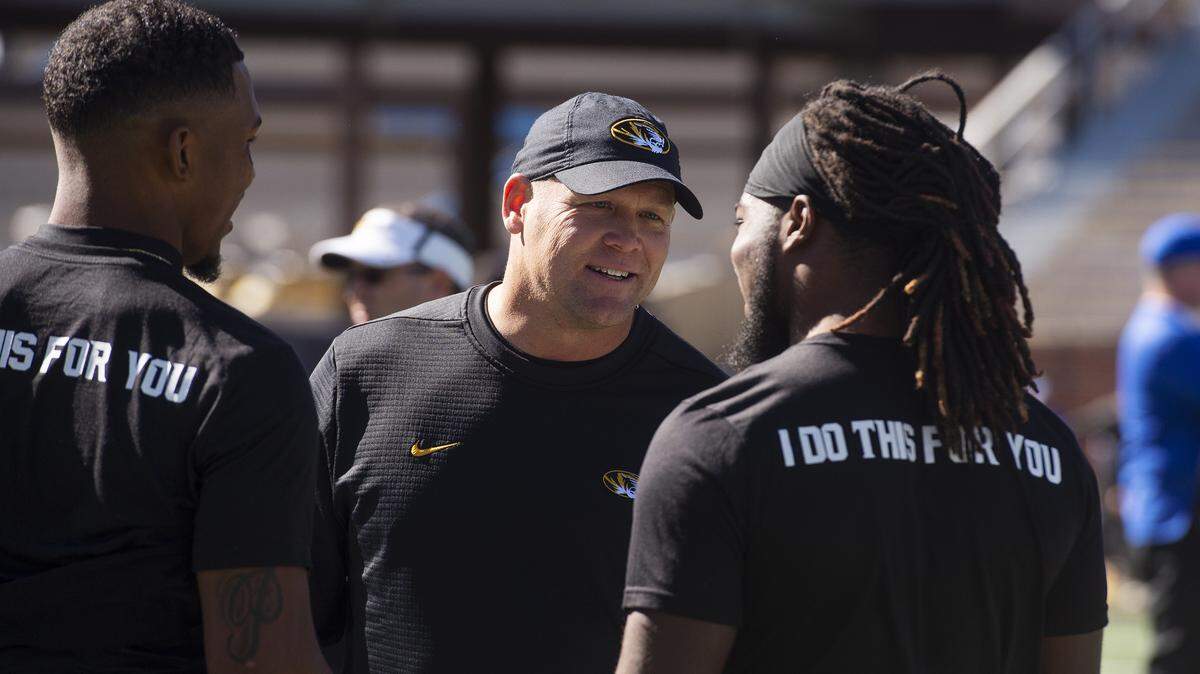 Missouri head football coach Barry Odom (center) was smiling before the game against Memphis, but he had to make a big decision on fourth down that turned the game in Missouri’s favor for good on Saturday.