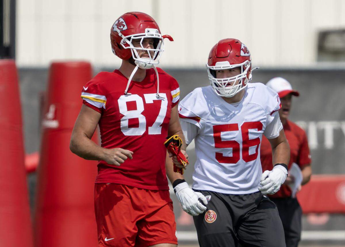 Kansas City Chiefs tight end Travis Kelce (87) and defensive end George Karlaftis (56) warm up during practice at team's training facility on Wednesday, August 20, 2025. in Kansas City