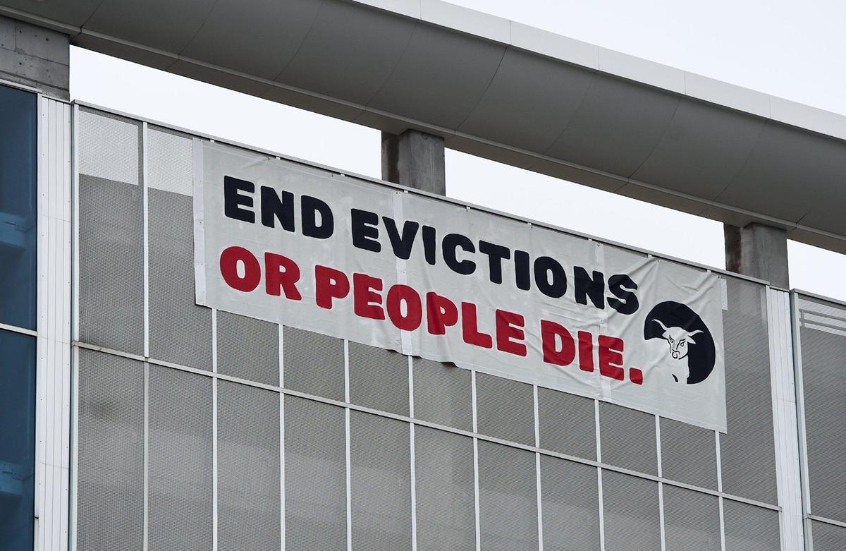 A banner hangs on a downtown parking garage as members of KC Tenants and tenants facing eviction rallied Thursday, July 30, outside the Jackson County Courthouse in Kansas City. The group is demanding Kansas City leaders to stop evictions during the COVID-19 pandemic and cancel rent.