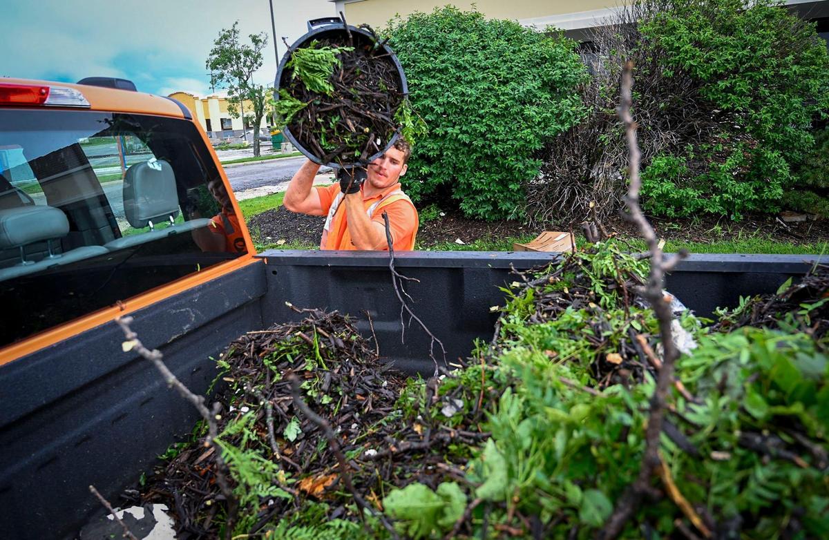 After a 2022 storm ripped across the area, Trevor Listor dumped storm debris into a pickup truck after it was collected from the parking lot at Quivira 95 Shops along 95th Street in Overland Park.