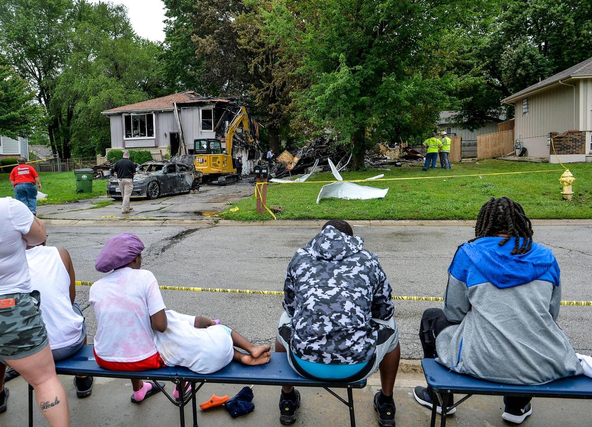 Family and neighbors watch Tuesday as law enforcement agencies dig through the rubble of a the duplex that exploded and caought fire in 7500 block of Englewood Avenue, Monday night in Raytown. Investigators found human ramains in the structure.