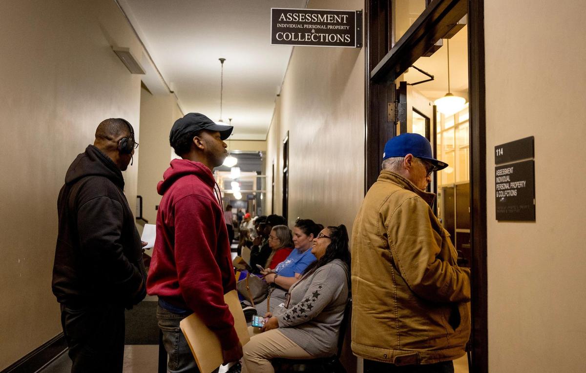People wait in line to work with staff at the Jackson County Assessment office on Friday, March 29, 2024, in Independence, Missouri.