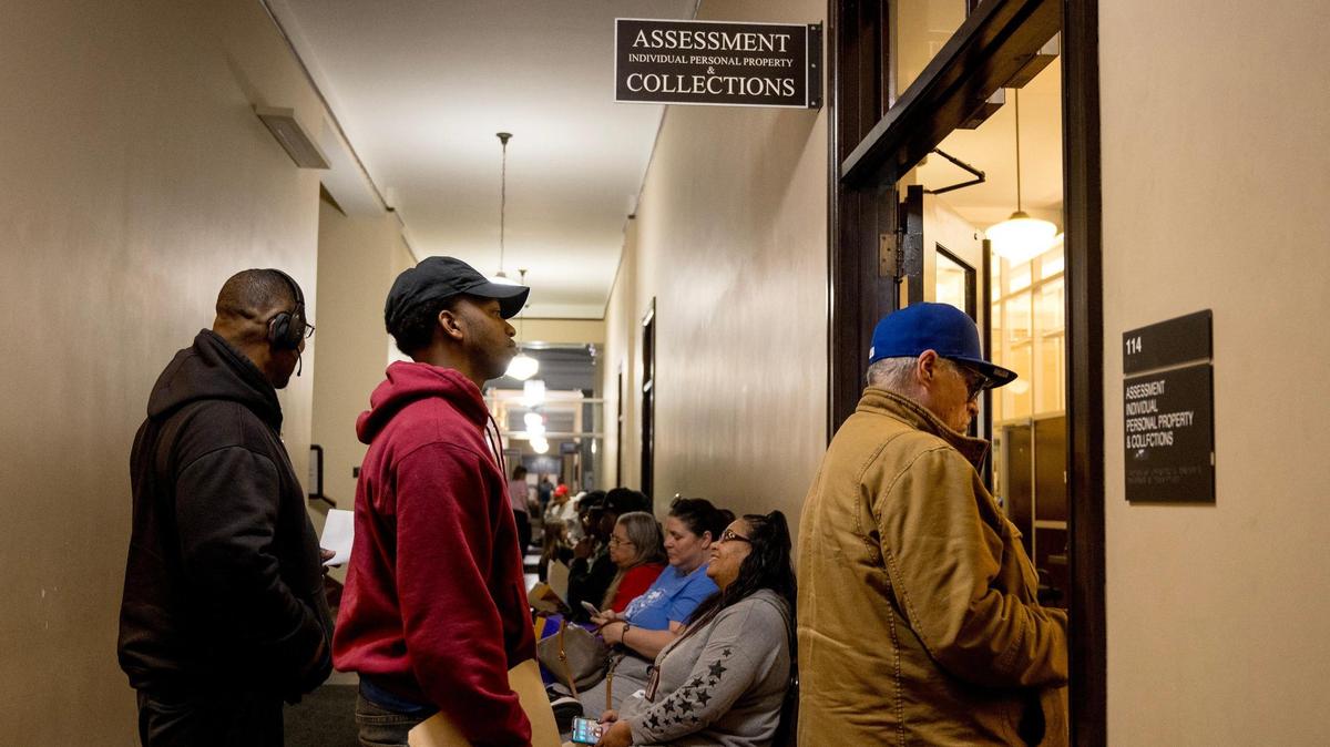 People wait in line to work with staff at the Jackson County Assessment office on Friday, March 29, 2024, in Independence, Missouri.