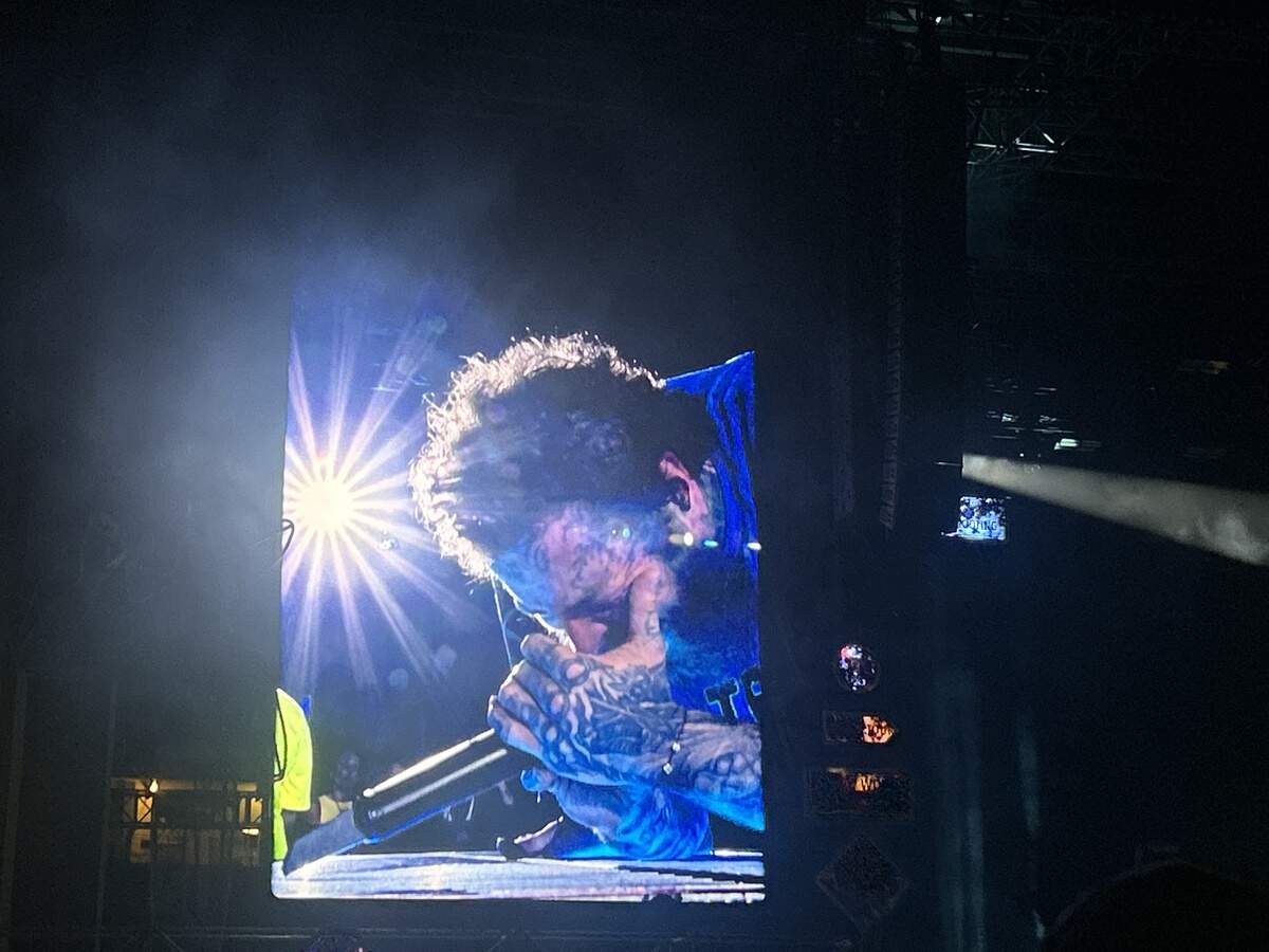 Post Malone sings crouched to the floor, lifting the mic from being propped up by the grates in the stage, on Wednesday night at Kauffman Stadium for his Kansas City leg of The Big Ass Stadium Tour Part 2.