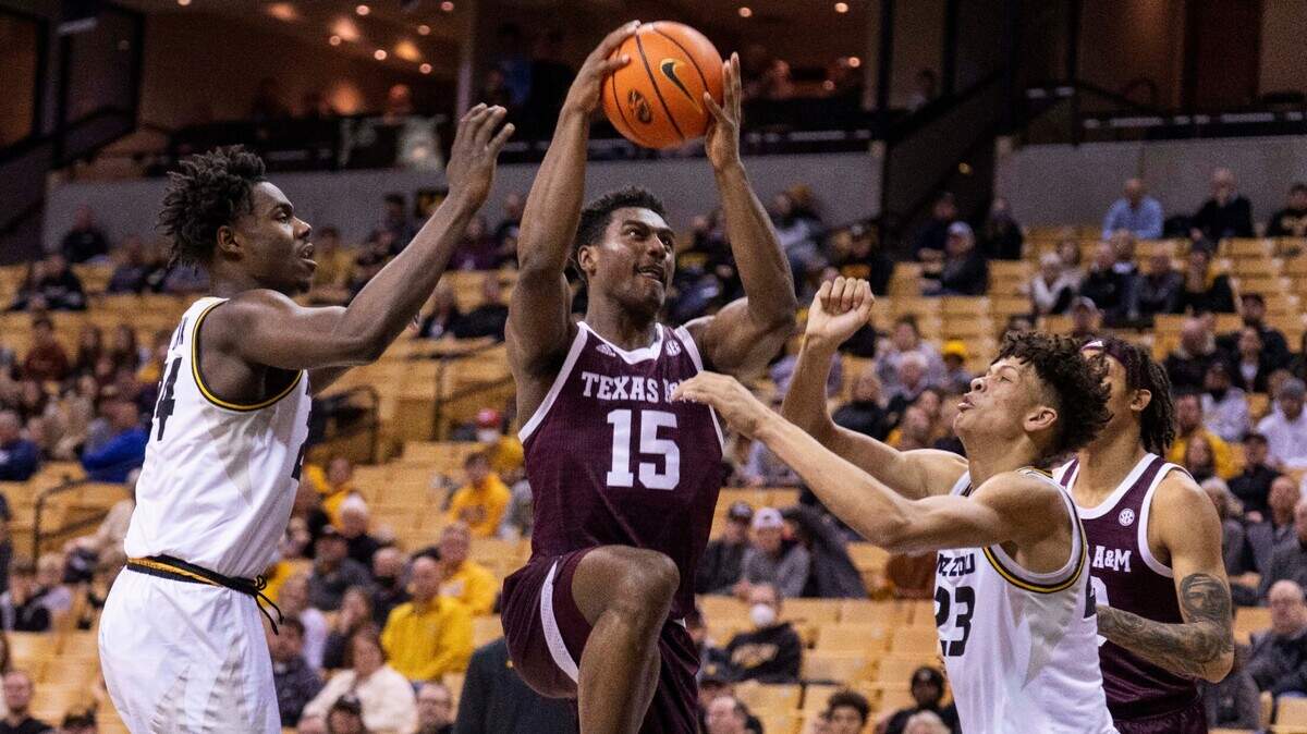 Texas A&M’s Henry Coleman III, left, shoots between Missouri’s Trevon Brazile, right, and Kobe Brown, left, during the first half of an NCAA college basketball game Saturday, Jan. 15, 2022, in Columbia, Mo. Texas A&M won 67-64. (AP Photo/L.G. Patterson)