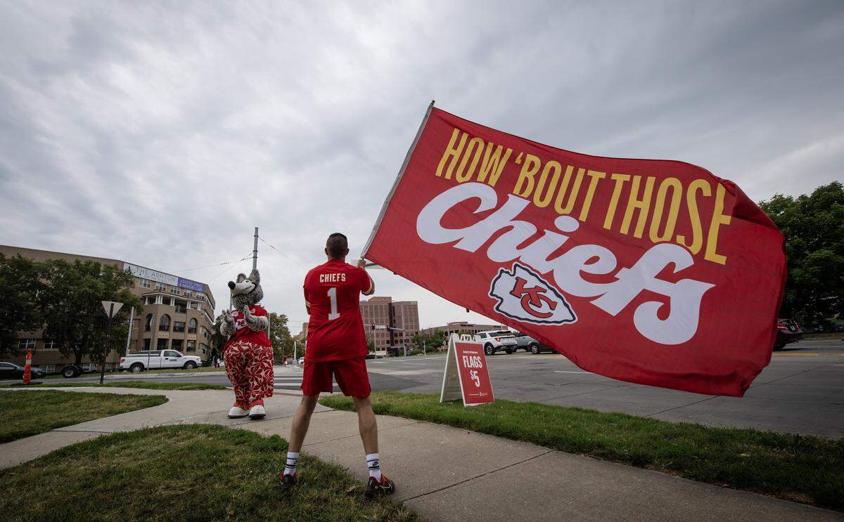 A Kansas City Chiefs flag bearer and mascot KC Wolf shared their Chiefs spirit during Red Friday kick off ceremonies on Friday, Sept. 5, 2024, at Mill Creek Park in Kansas City.