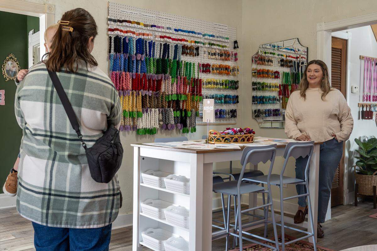Sydney Kinkade, owner of The Parkville Needlepoint House, assists a customer on Wednesday, Feb. 11, 2026, at the shop in Parkville.
