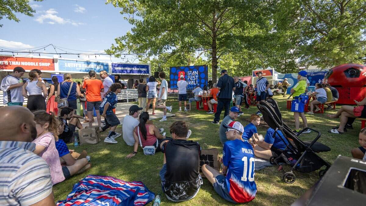 Visitors lounge on the grass near the concession stands while attending the FIFA Fan Festival on Sunday, June 14, 2026, in Kansas City.