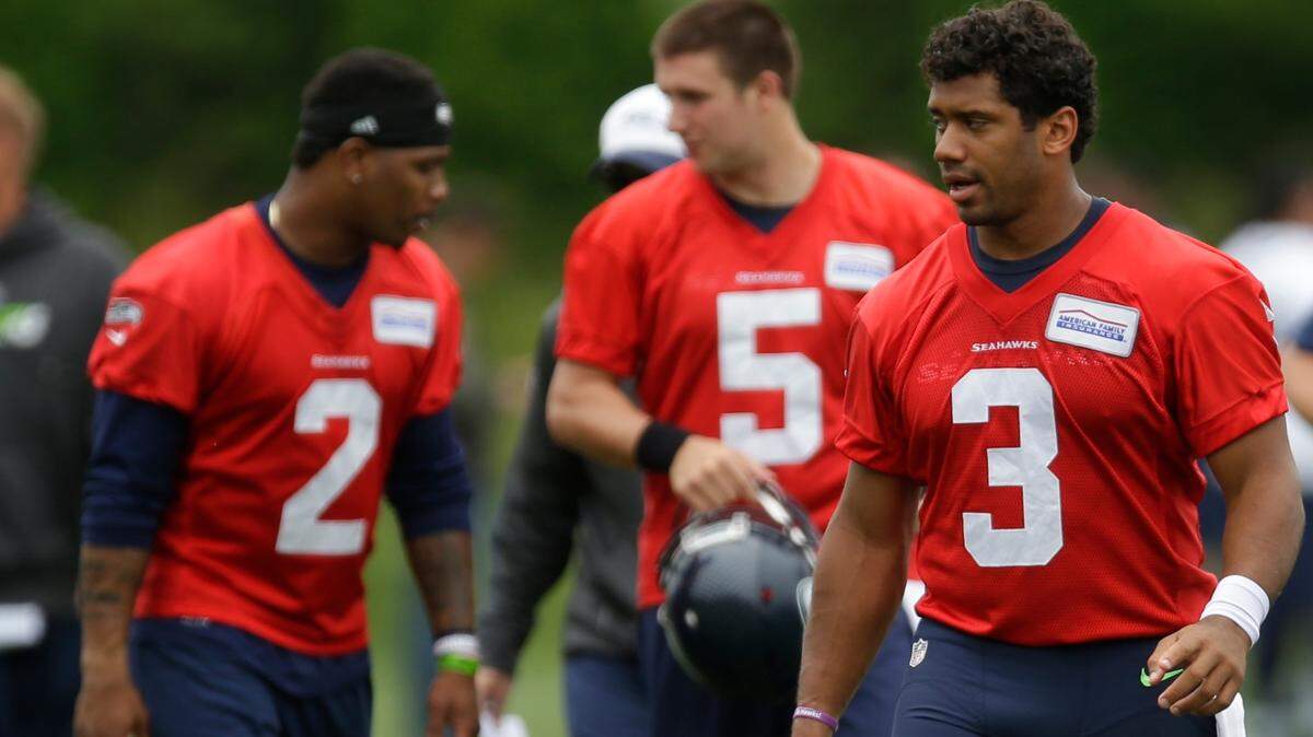 Seattle Seahawks quarterback Russell Wilson (3) walks off the field with backup quarterbacks Trevone Boykin (2) and Jake Heaps (5) after NFL football practice, Thursday, June 9, 2016, in Renton, Wash. (AP Photo/Ted S. Warren)