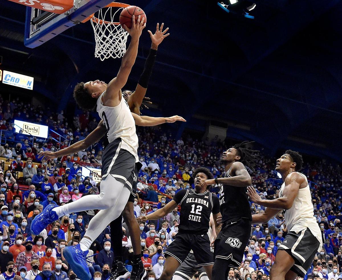 KU’s Jalen Wilson drives past OSU’s Keylan Boone for a reverse layup during the second half of Monday night’s Big 12 Conference game at Allen Fieldhouse. KU beat OSU, 76-62.