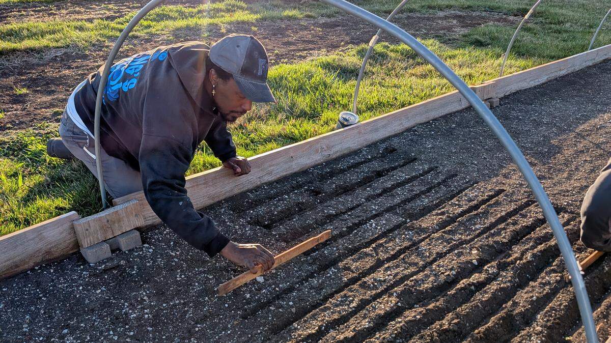 A volunteer prepares a garden bed at a Johnson County community garden.