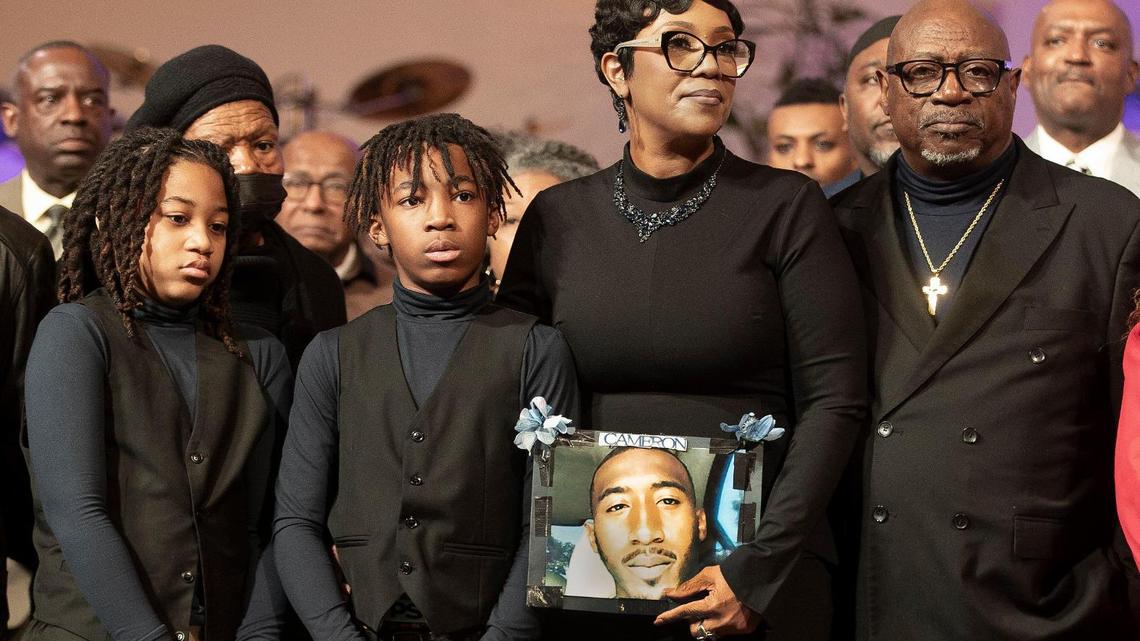 Laurie Bey, mother of Cameron Lamb, who was shot and killed on Dec. 3, 2019 by Kansas City Police Det. Eric DeValkenaere holds a photo of her son at an event celebrating the Rev. Dr. Martin Luther King Jr.  She is surrounded by family, friends, clergy and supporters at St. James United Methodist Church for a press conference prior to the event denouncing DeValkenaere’s release in December after serving just over one year in prison.